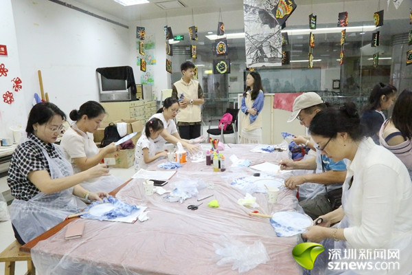 活动现场。 深圳新闻网龙岗讯(记者 李云云 通讯员 谢绍花)9月1日,龙岗区文化馆在三楼创玩空间开展了创意手工扎染展览及手工扎染体验活动,吸引众多青年、儿童参加。 展览区域展出了宫扇、灯笼、裙子、桌布等80余件手工制作的布制品及姜黄素、洋葱等十余种植物染料和活性染料。手工扎染体验活动现场,扎染老师现场教学,参与者通过观看视频学习了解扎染知识及制作技艺,还实地体验了一把手工织物扎结、染色等过程。参与者根据自己的喜好,做出不同图案、不同尺寸的扎染作品、有得把布染成条纹状、有的染成螺旋状、有的把白布鞋吊起来染
